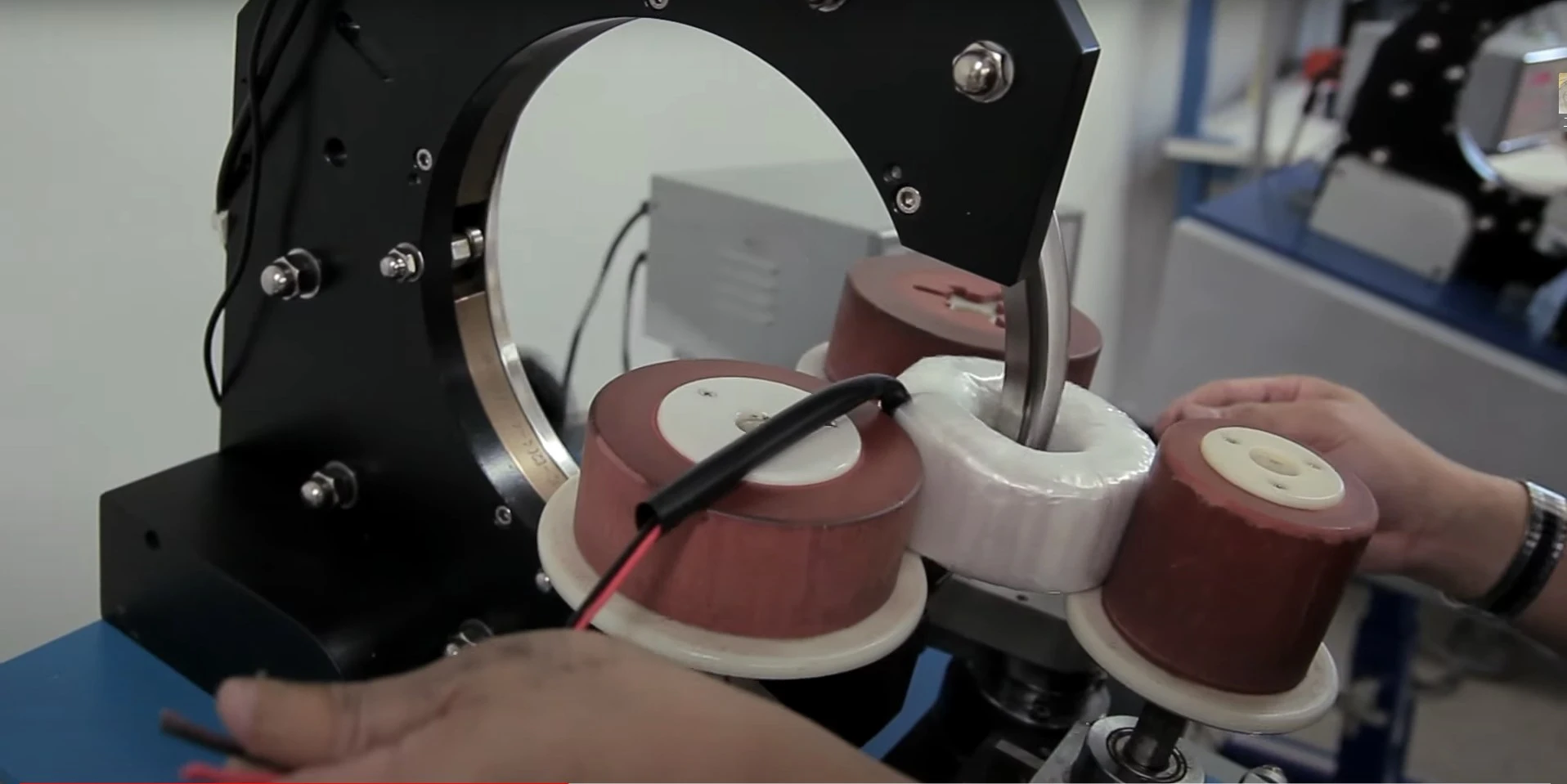 特寫鏡頭：一名技術人員正在操作用於製造EMIRFI抑制元件的線圈繞線機，展示繞線製程的先進技術和精度