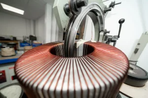 A machine winding copper wire onto a toroidal core